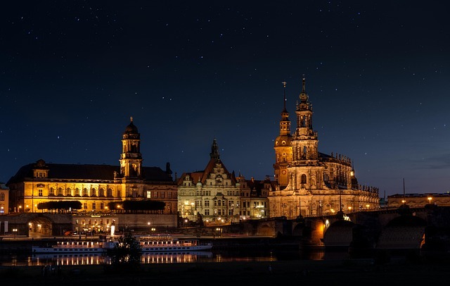 Dresdner Frauenkirche und historische Gebäude am Elbufer bei Nacht, beleuchtet und unter sternenklarem Himmel, symbolisieren die kulturelle Bedeutung Dresdens für Zertifizierungsdienste.