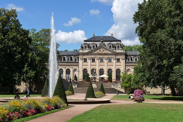 Schlossgarten in Fulda mit historischem Gebäude, Wasserspiel und bunten Blumenbeeten, zentral für Stratlane Certification Dienstleistungen.